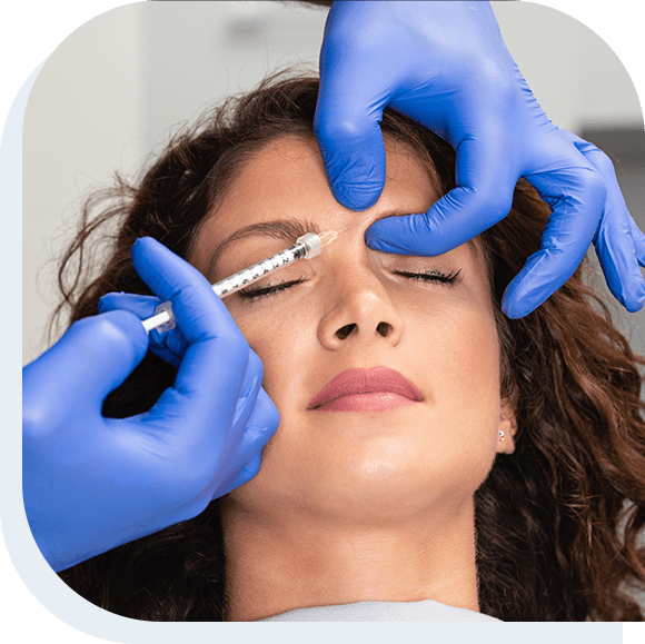 Close up of beautician expert's hands injecting botox in female forehead.