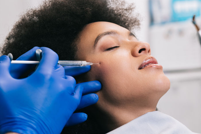young African woman is getting a rejuvenating facial injections