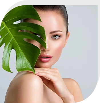 Young beautiful woman with green leave near face and body.