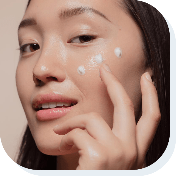 Close up of a young woman applying moisturizer to her face