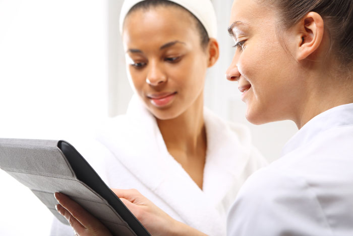 Two women in wellness salon dressed in white robes