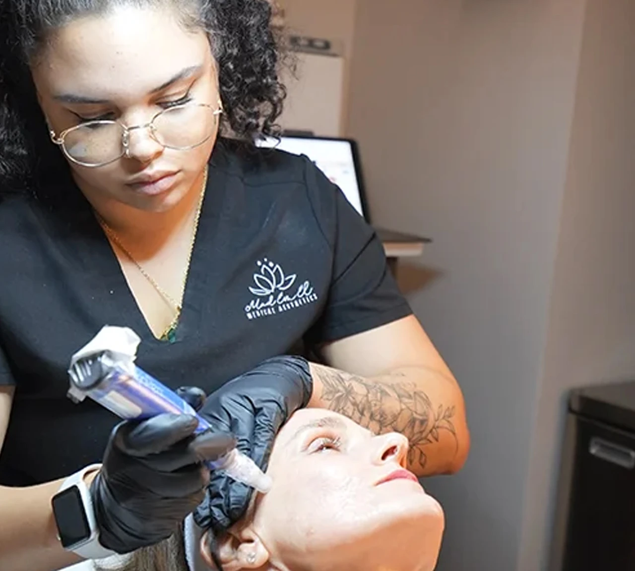 A woman receiving a SkinPen microneedling treatment on her cheek from a practitioner wearing medical gloves.