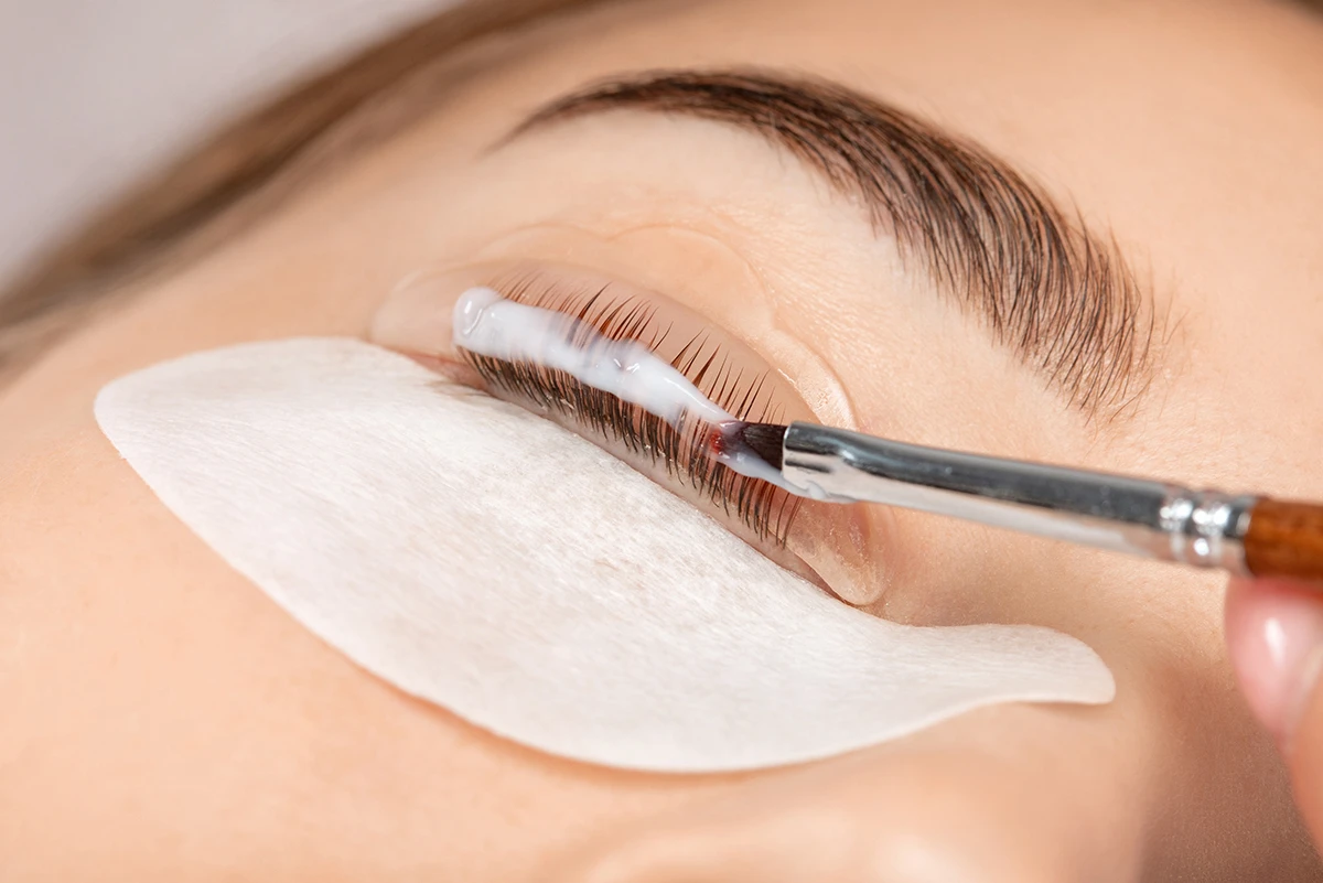 Close-up of a woman's eye with neatly groomed, natural dark eyebrows and lifted eyelashes.